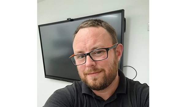 Man with glasses smiling at camera