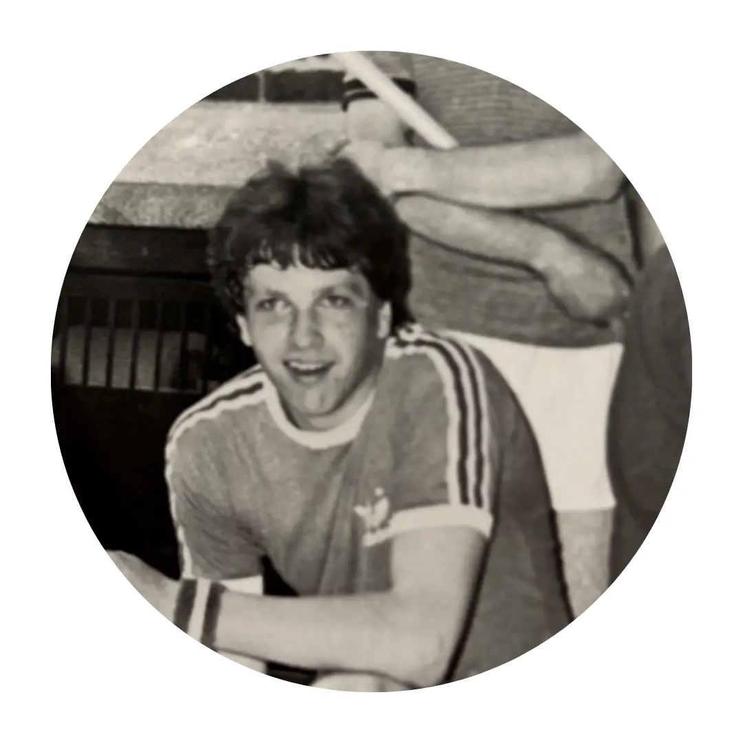 Black and white photo of Andrew Boozer. He is wearing a short-sleeved sports shirt with stripes on the sleeves and a wristband.