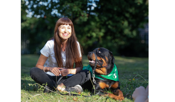 lady smiling with black and brown dog