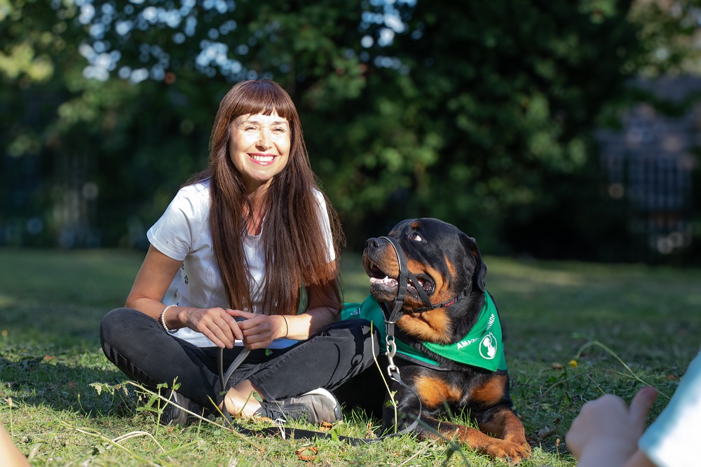 lady smiling with black and brown dog