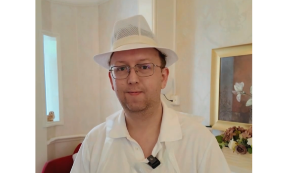 man smiling in white hat at camera