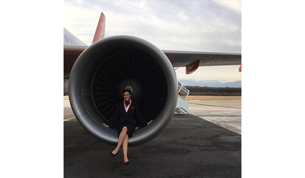 girl sitting on the edge of a plane engine when it's stationary 