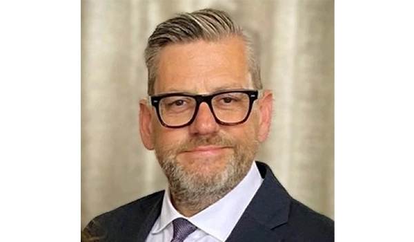 man smiling at camera wearing glasses