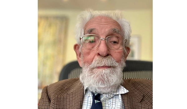 man with white beard and glasses smiling at camera