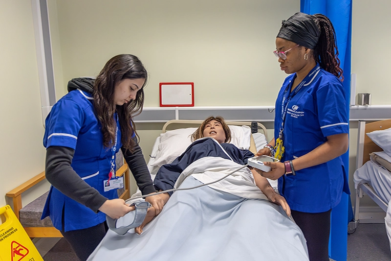 Two students caring for patient