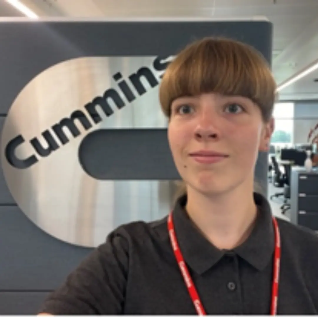 Isabel looking at the camera with the Cummins logo behind her.