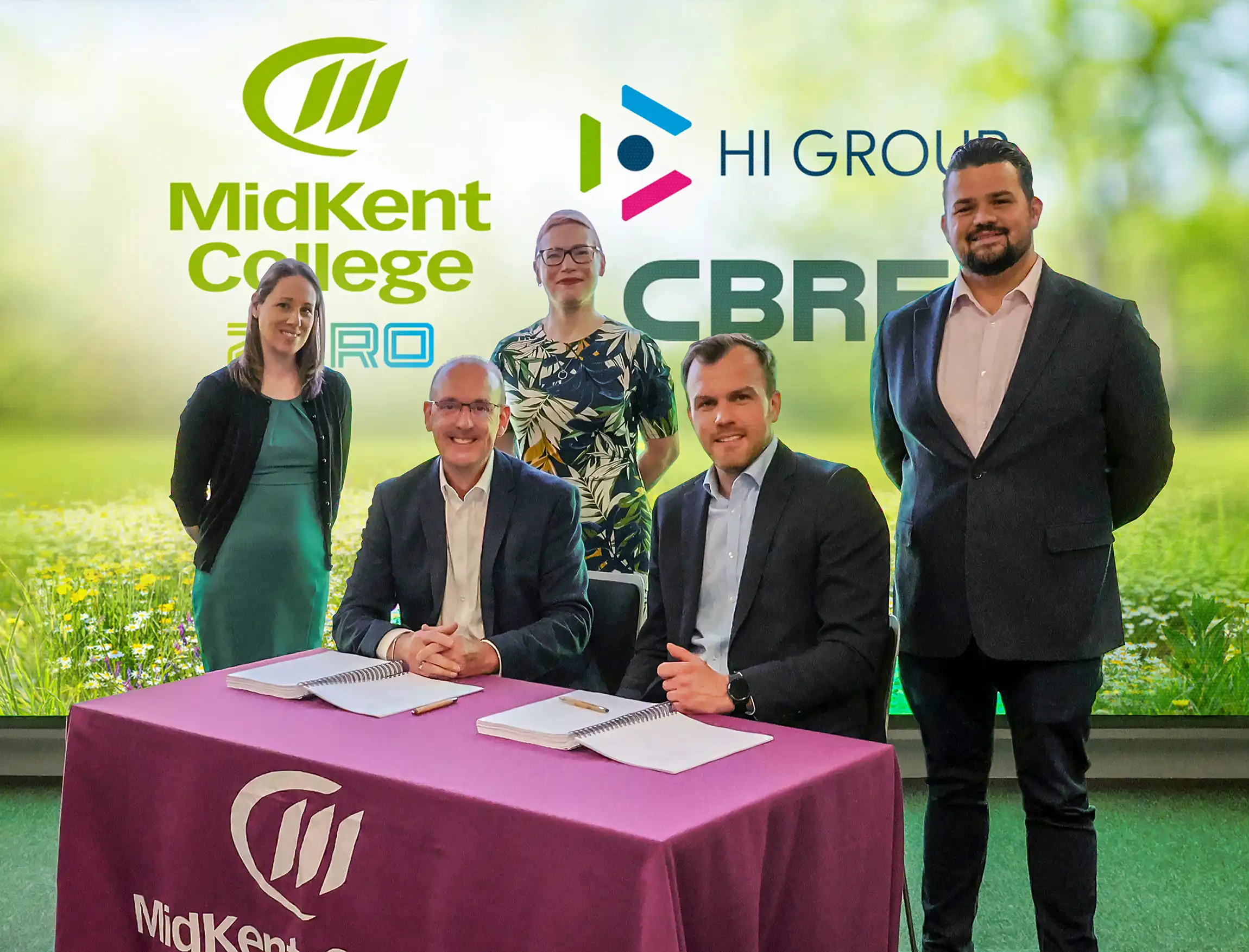 HI Group and executives gathered around table smiling at camera