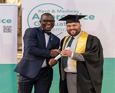 Jordan Leach (right) shaking hands whilst being presented with graduated award.