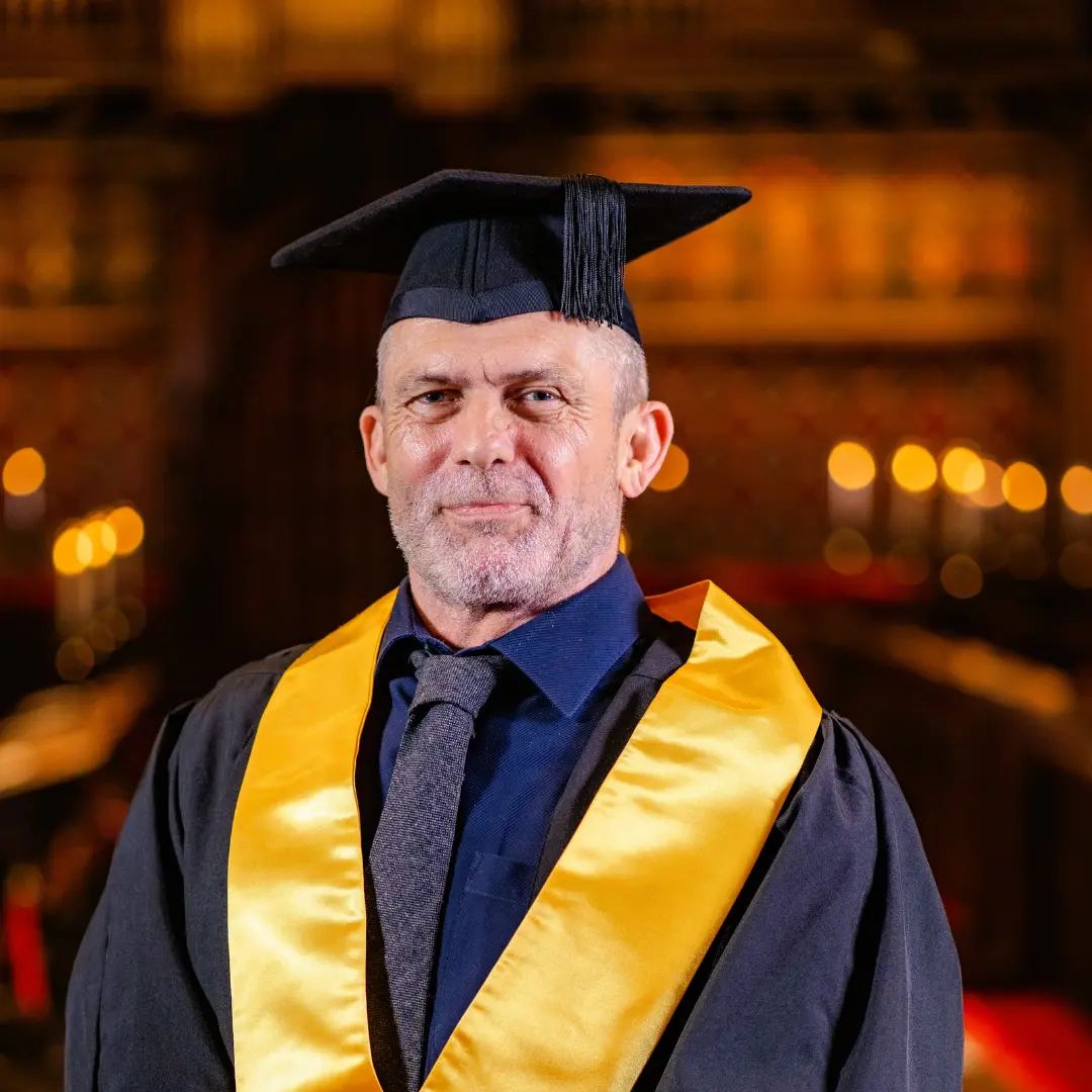 Tony wearing a graduation cap and gown.