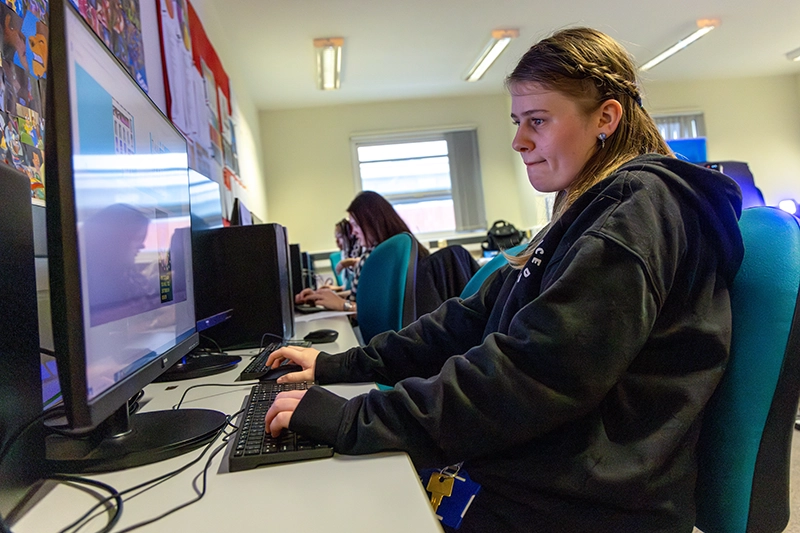 Student using the desktop computer in classroom