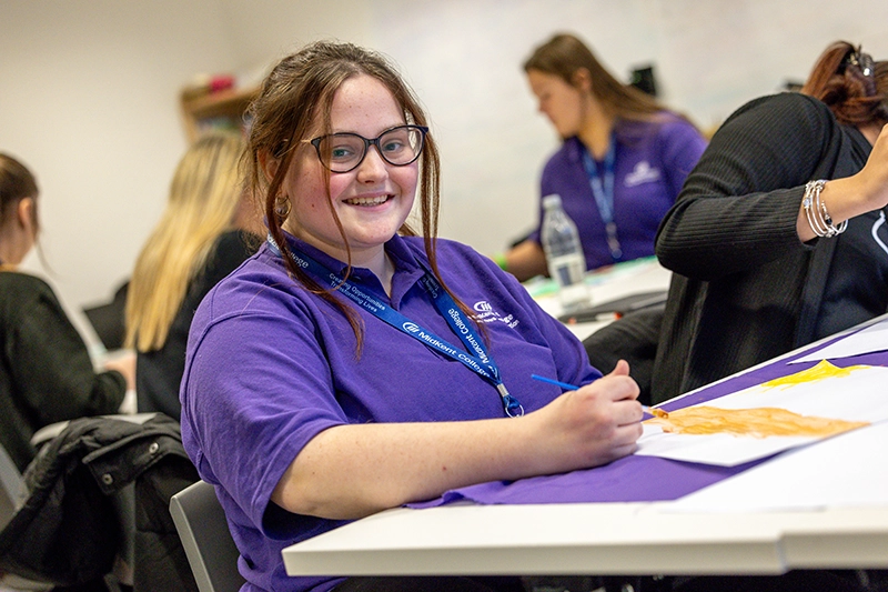 Student posing in classroom setting