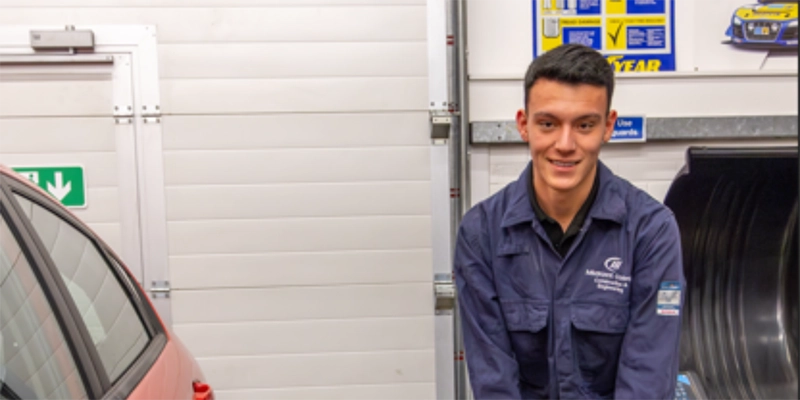 Student posing in the motor vehicle workshop