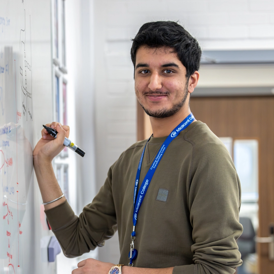Student writing on the white-board in classroom setting