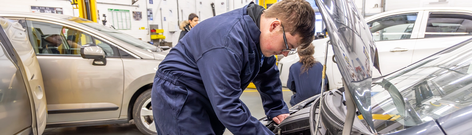 Motor Mechanic students work on cars in the workshops