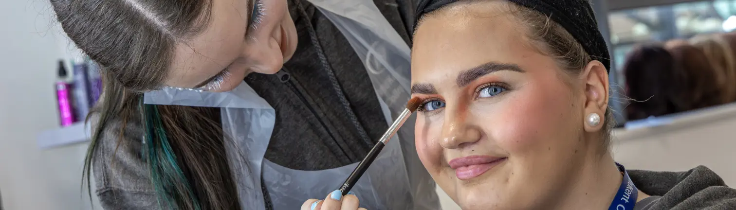 Beauty Therapy student applying makeup with brush to another student