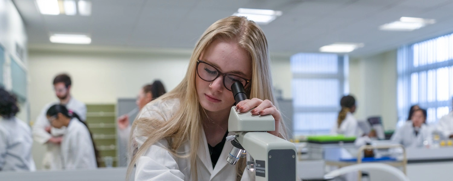 Applied Science student uses a microscope at MidKent College