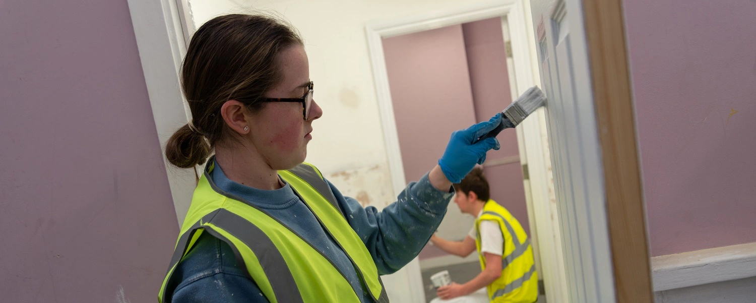 Painting and Decorating student applies gloss to a door