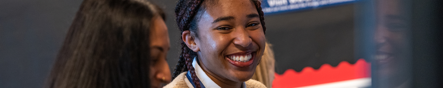 Student smiling at a friend in class