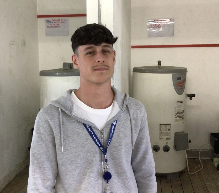 Student posing in the plumbing workshop