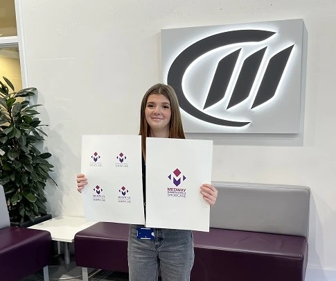 Graphics student holding winning design